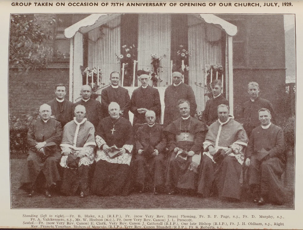 Group photograph outside the church, marking the 75th anniversary of its opening, July 1929. Clergy stand and sit before a decorated outdoor altar, named in the printed caption.